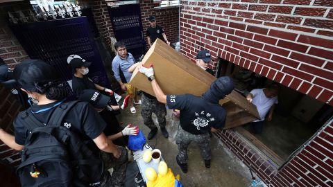 Soldiers carry debris from a flooded house in Seoul, South Korea, on Aug. 10.