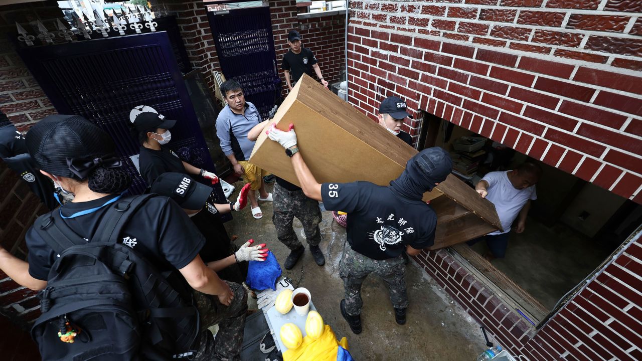 Soldiers carry debris out from a flooded house in Seoul, South Korea, on August 10.