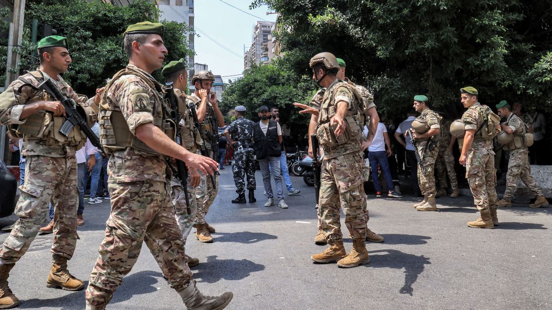 Army soldiers gather near a "Federal Bank" branch in Lebanon's capital Beirut on August 11, 2022. - A customer armed with a rifle and threatening to set himself ablaze held bank workers hostage on August 11 in Lebanon's capital demanding to withdraw his savings of over $200,000, security sources said. 