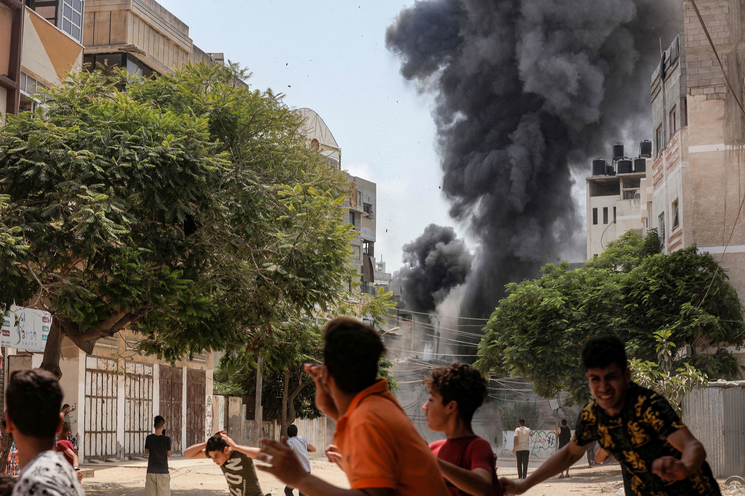 People run for cover after an explosion in Gaza City on Saturday, August 6.