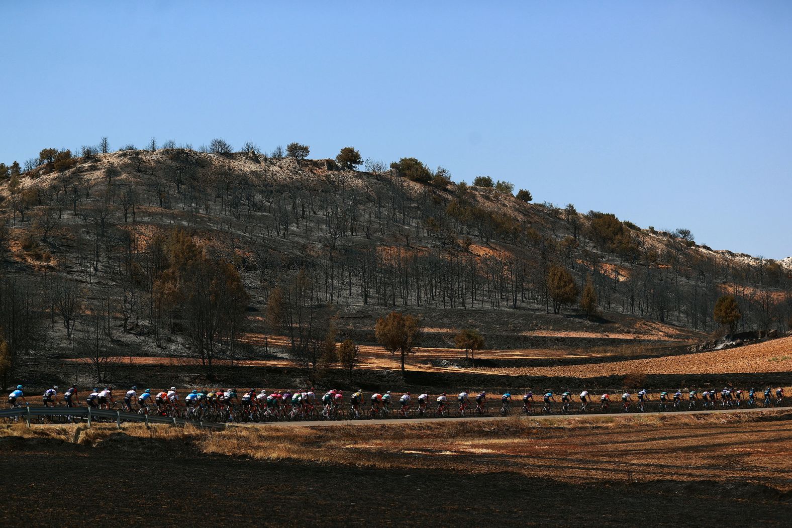 A burnt landscape is seen in Neila, Spain, as cyclists compete during the fifth stage of the Vuelta a Burgos on Saturday, August 6.