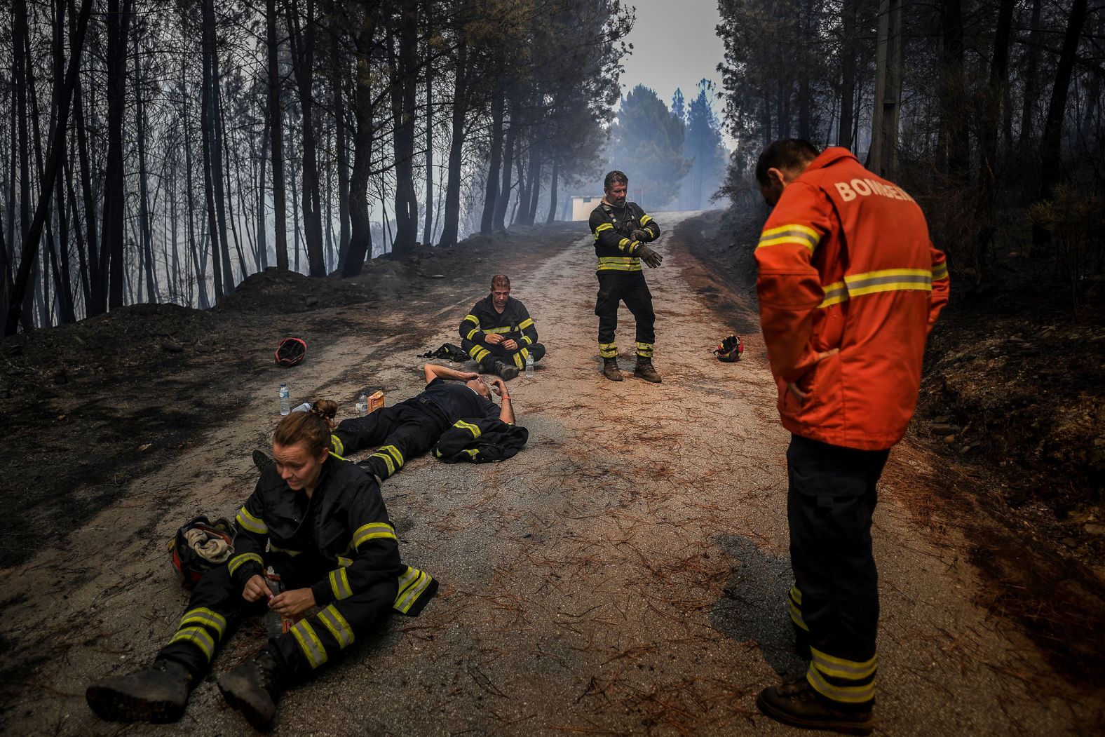 Firefighters drink water and recover while fighting a wildfire in the Portuguese village of Sameiro on Wednesday, August 10.