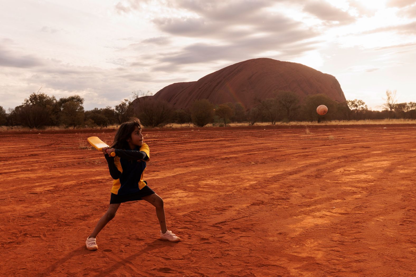 A child plays cricket in Mutitjulu, an Aboriginal community in Uluru, Australia, on Tuesday, August 9. The community was one of the stops on the ICC Men's T20 World Cup Trophy Tour.