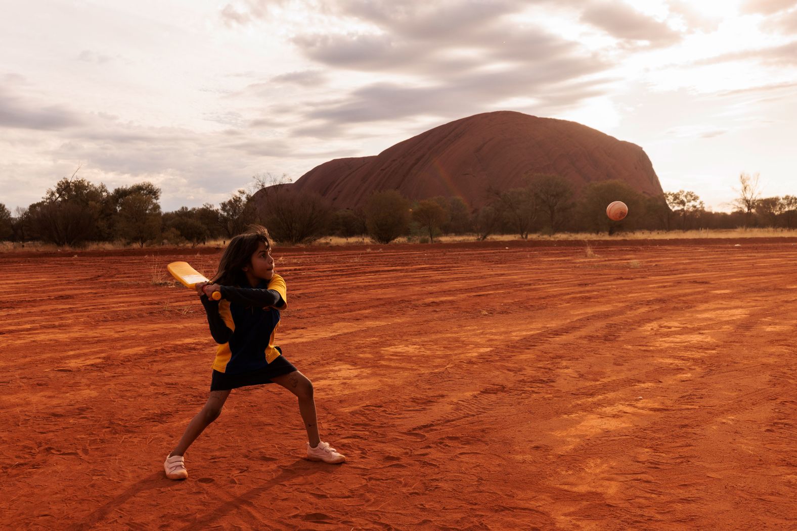 A child plays cricket in Mutitjulu, an Aboriginal community in Uluru, Australia, on Tuesday, August 9. The community was one of the stops on the ICC Men's T20 World Cup Trophy Tour.