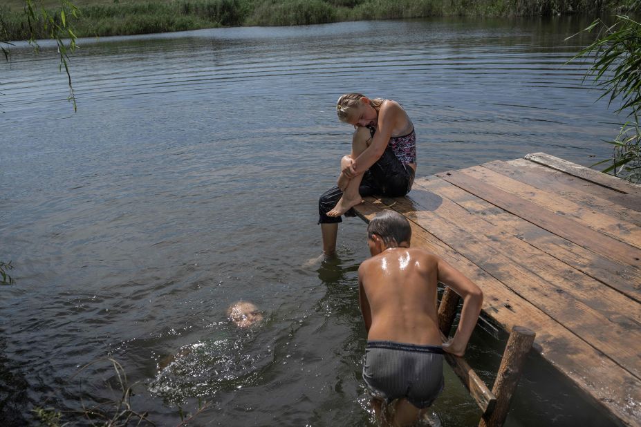 Ukrainian children play in a lake in the country's eastern Donbas region on Monday, August 8.