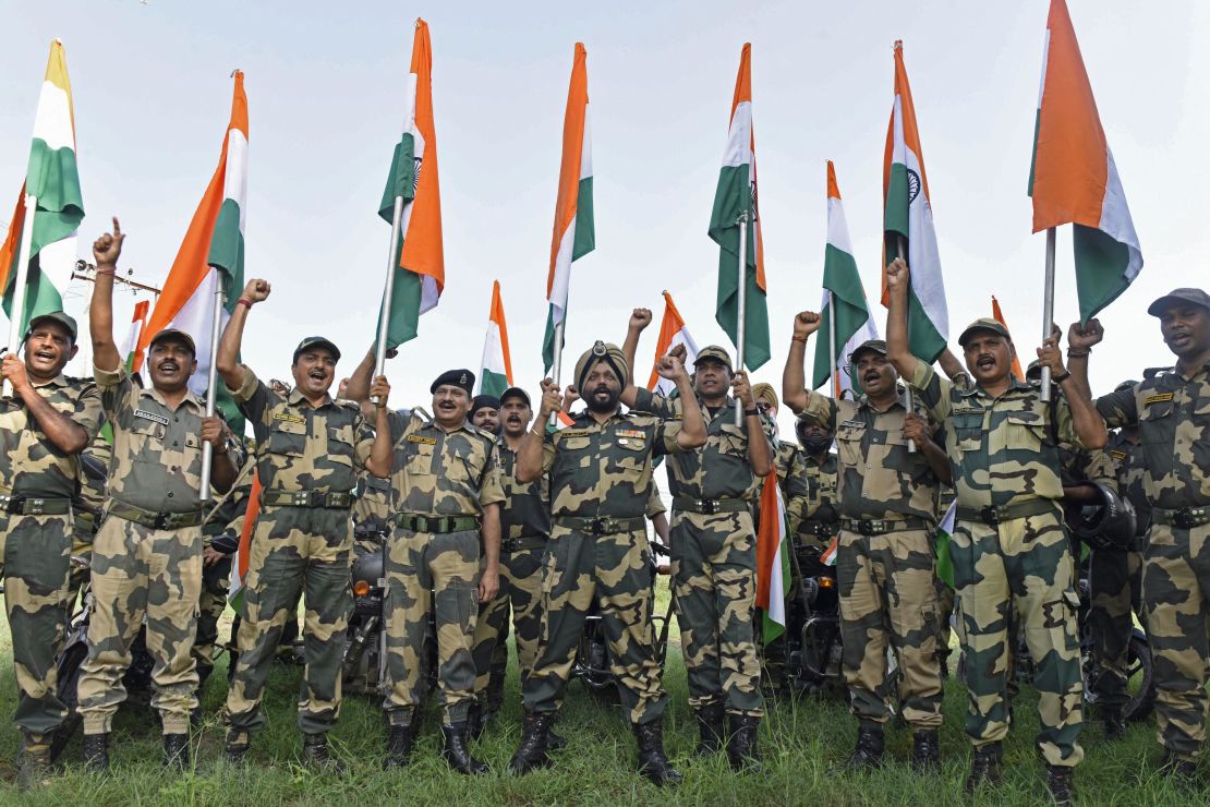 Indian Border Security Force soldiers hold the national flag during a motorbike rally ahead of the 75th anniversary of country's independence at the India-Pakistan border outpost in Panjgrain, about 60km from Amritsar on August 10, 2022.