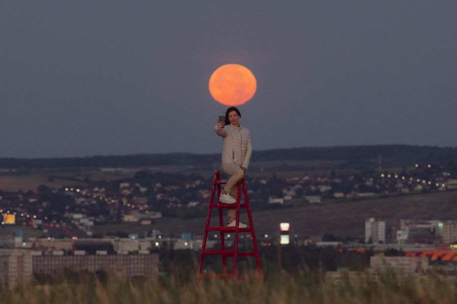 A moon gazer takes a selfie as the supermoon sets in the early morning hours above Kosice, Slovakia, on August 12.