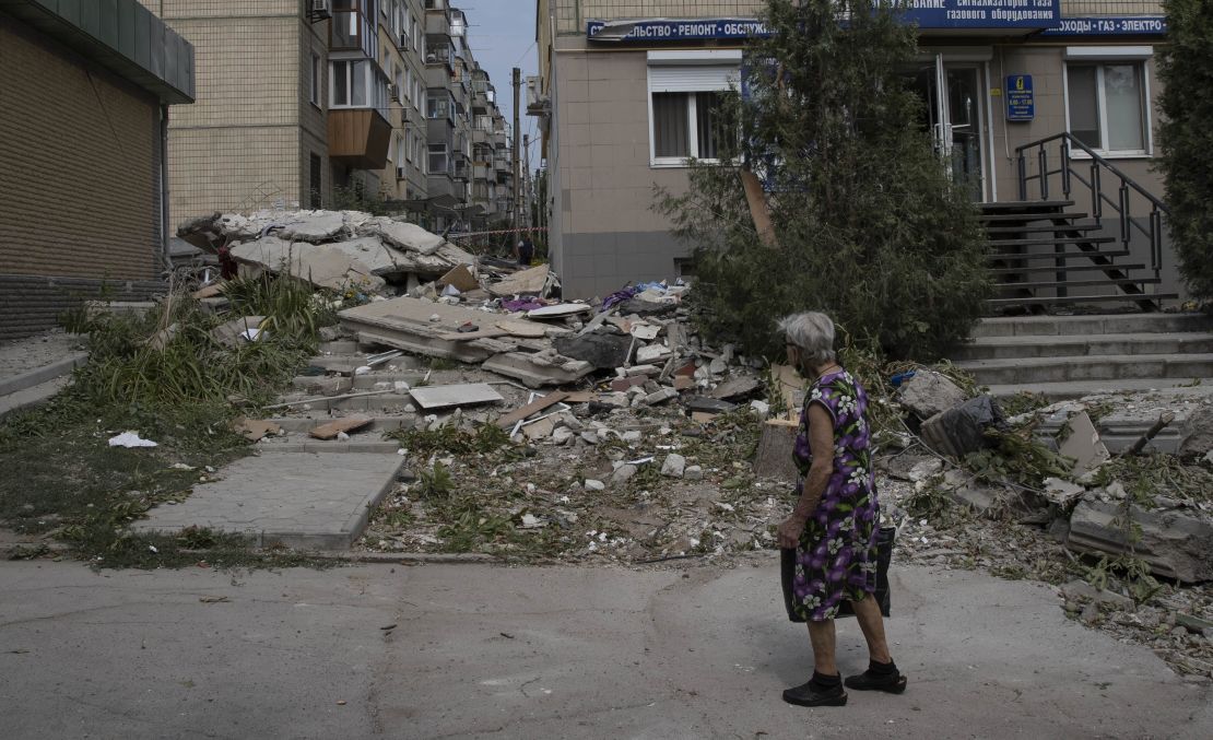 A woman assesses the damage on a street in Nikopol, where residents say they are living under a relentless barrage of rockets.