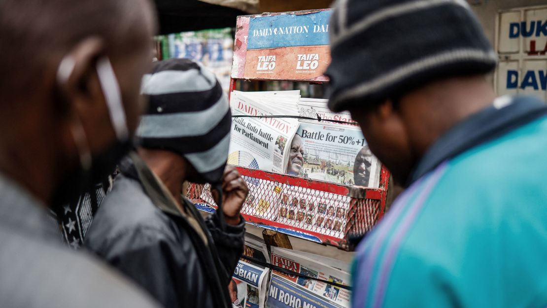 Residents look at newspapers displayed at a stand in Mathare, Nairobi, on August 12, 2022, following Kenya's general election. 