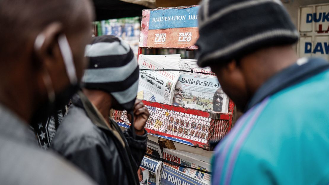 Residents look at newspapers displayed at a stand in Mathare, Nairobi, on August 12, 2022, following Kenya's general election.