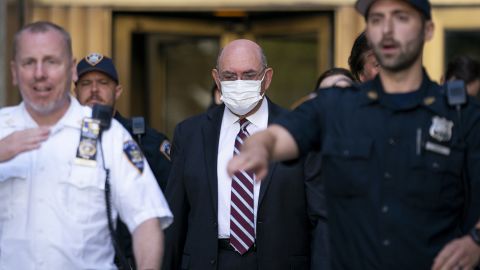 Law enforcement personnel escort the Trump Organization's former Chief Financial Officer Allen Weisselberg, center, as he departs court August 12, 2022, in New York. 