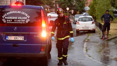 Un bombero camina junto a un coche fúnebre en el lugar del ataque en Cetinje, 36 kilómetros (22 millas) al oeste de Podgorica, Montenegro, el viernes 12 de agosto de 2022. 