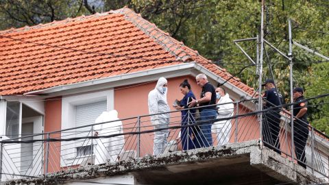 La fiscal estatal Andrijana Nastic habla con el equipo forense en la casa donde un hombre armado inició un tiroteo masivo en Cetinje, Montenegro, el 12 de agosto de 2022.