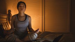woman meditating in bed STOCK