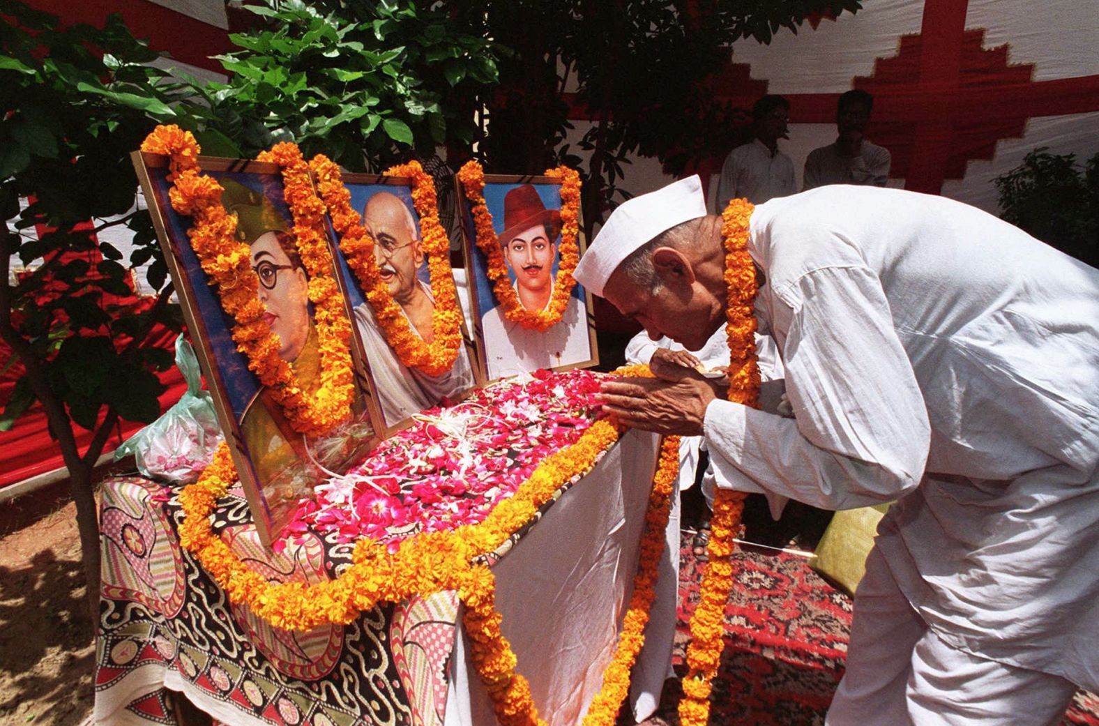 A man bows before a shrine to Mahatma Gandhi and other independence leaders on August 13, 1997, ahead of India's 50th independence day celebrations.