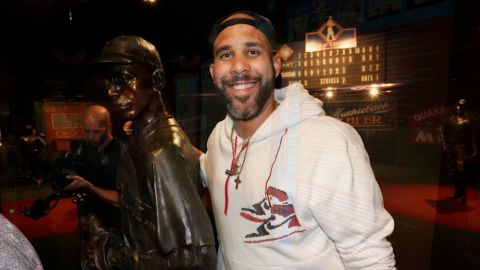 Dodgers pitcher David Price poses with a statue of Satchel Paige.