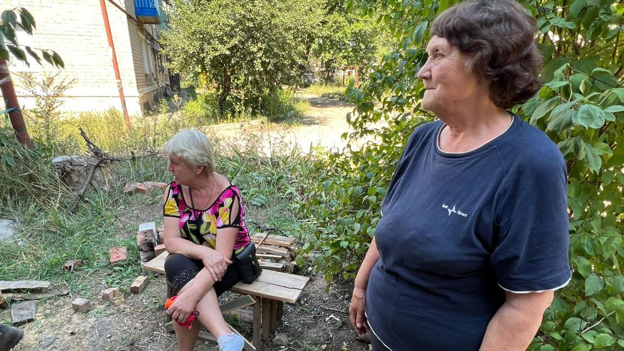 Siversk residents, Valeria Mazina (L) and Svetlana (R) cook in the street.
