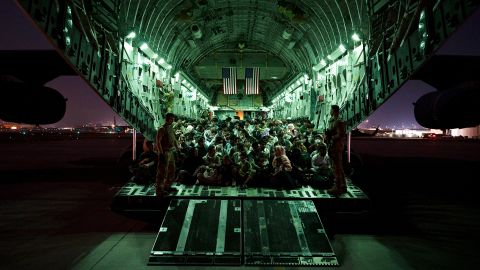In this handout provided by the US Air Force, an air crew assigned to the 816th Expeditionary Airlift Squadron assists evacuees aboard an aircraft in support of the Afghanistan evacuation at Hamid Karzai International Airport on August 21, 2021 in Kabul, Afghanistan. 