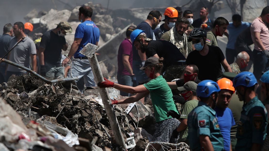 Emergency workers and volunteers at the site of the market on Monday.