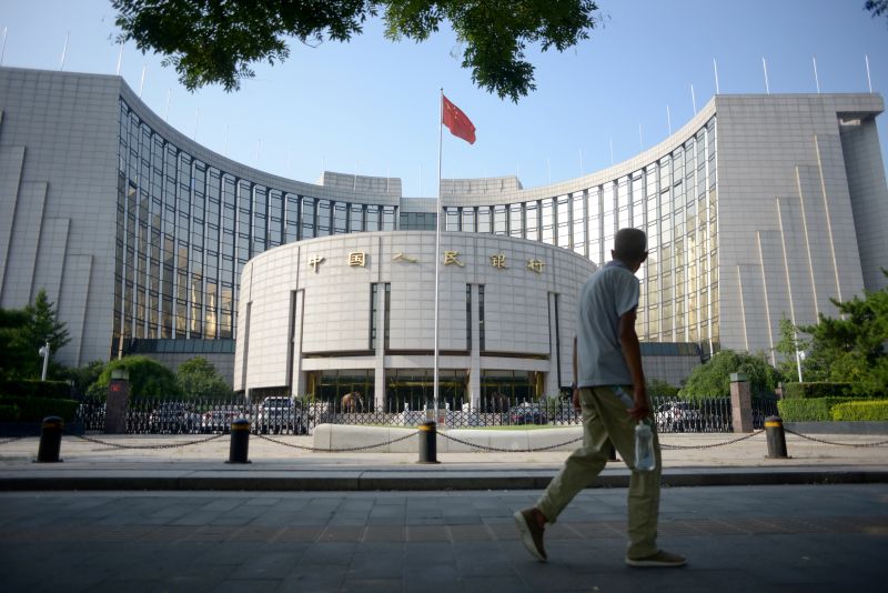 An elderly man walks past the People's Bank of China in Beijing on August 12, 2015. China cut the yuan's value against the US dollar for the second consecutive day on August 12, roiling global financial markets and driving expectations the currency could be set for further falls.      AFP PHOTO / WANG ZHAO (Photo by WANG Zhao / AFP) (Photo by WANG ZHAO/AFP via Getty Images)
