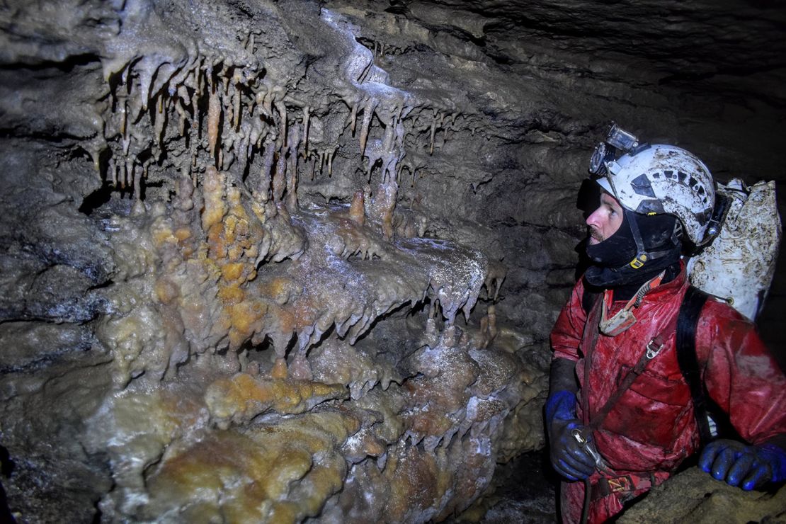 STC member Brendan Moore examines a cave formation.