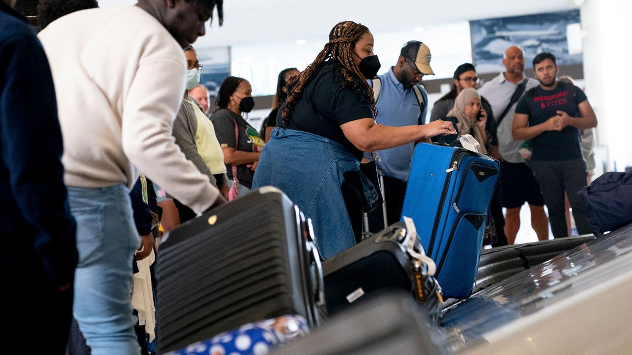 Travelers pick up their baggage while arriving at Ronald Reagan Washington National Airport in Arlington, Virginia, on July 2, 2022. 
