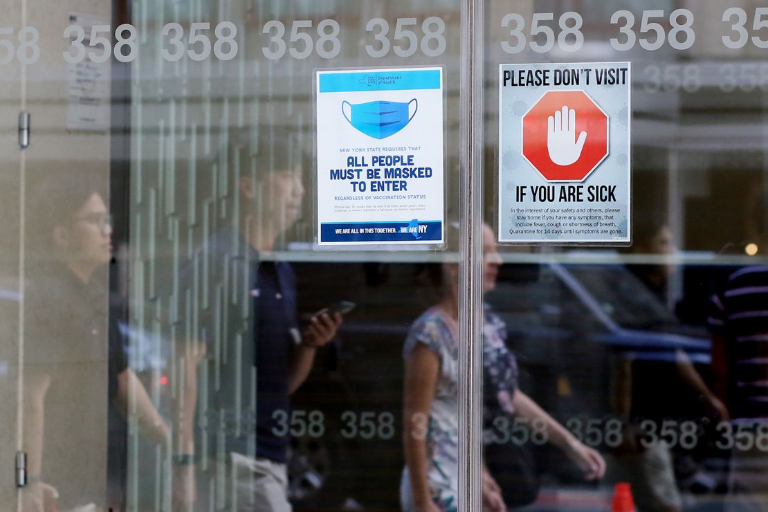 Signage requesting mask usage and Covid-19 safety precautions are displayed at a building on July 9 in New York City.