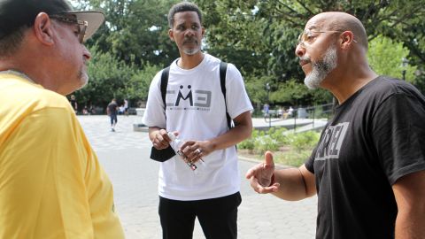 Clinton Lacy listens to Bishop David Maldonado and Antonio Fernandez at Maria Hernandez Park, in Bushwick, Brooklyn, on July 31, 2022.