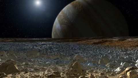 This illustration shows a simulated view from the icy surface of Jupiter's moon Europa, with the giant planet behind it. 