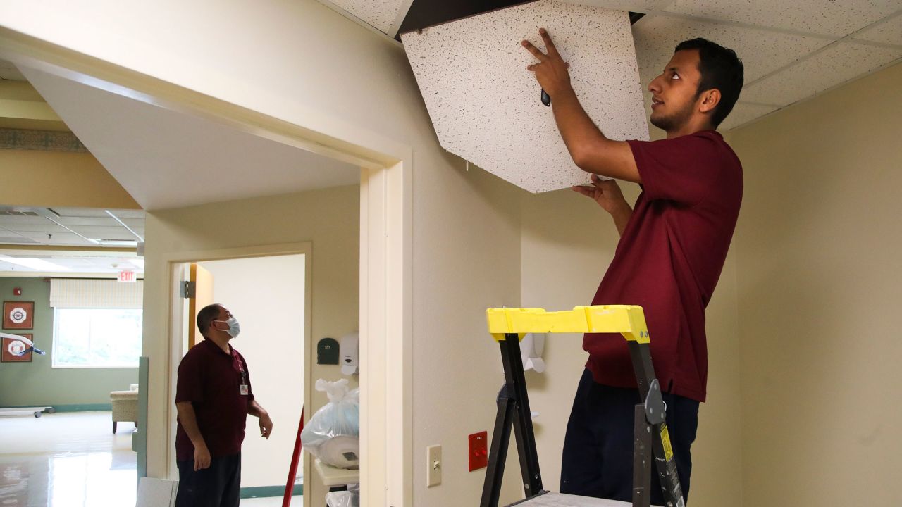 Suliman Raoufi, 19, who works in building maintenance, works to replace panels in the drop ceiling at a senior community in Bradenton, Florida, in July 2022. 