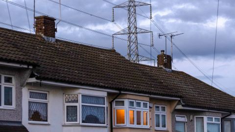 An electricity transmission tower near residential houses in Upminster, UK, on Monday, July 4, 2022. 