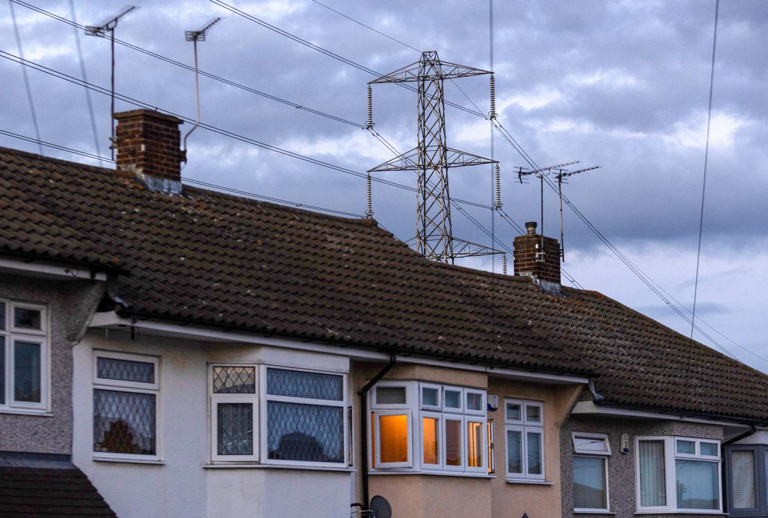 An electricity transmission tower near residential houses in Upminster, UK, on Monday, July 4, 2022. 