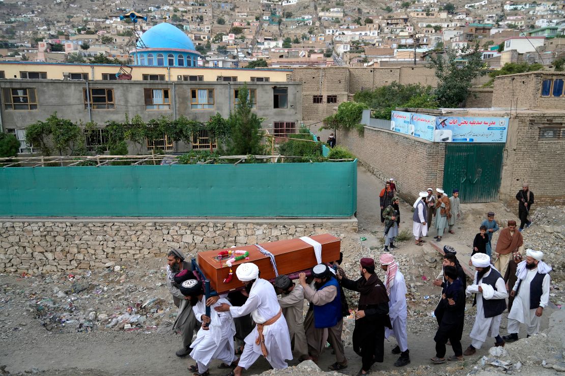 Mourners carry the body of a victim of the Kabul mosque bombing on August 18. 2022. 