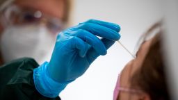 30 June 2022, Berlin: A woman is tested for coronavirus at a testing center. 