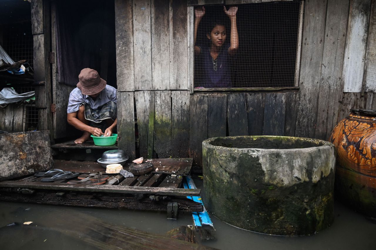 A girl looks out the window of her house surrounded by floodwaters on the outskirts of Yangon, Myanmar, on Wednesday, August 17.