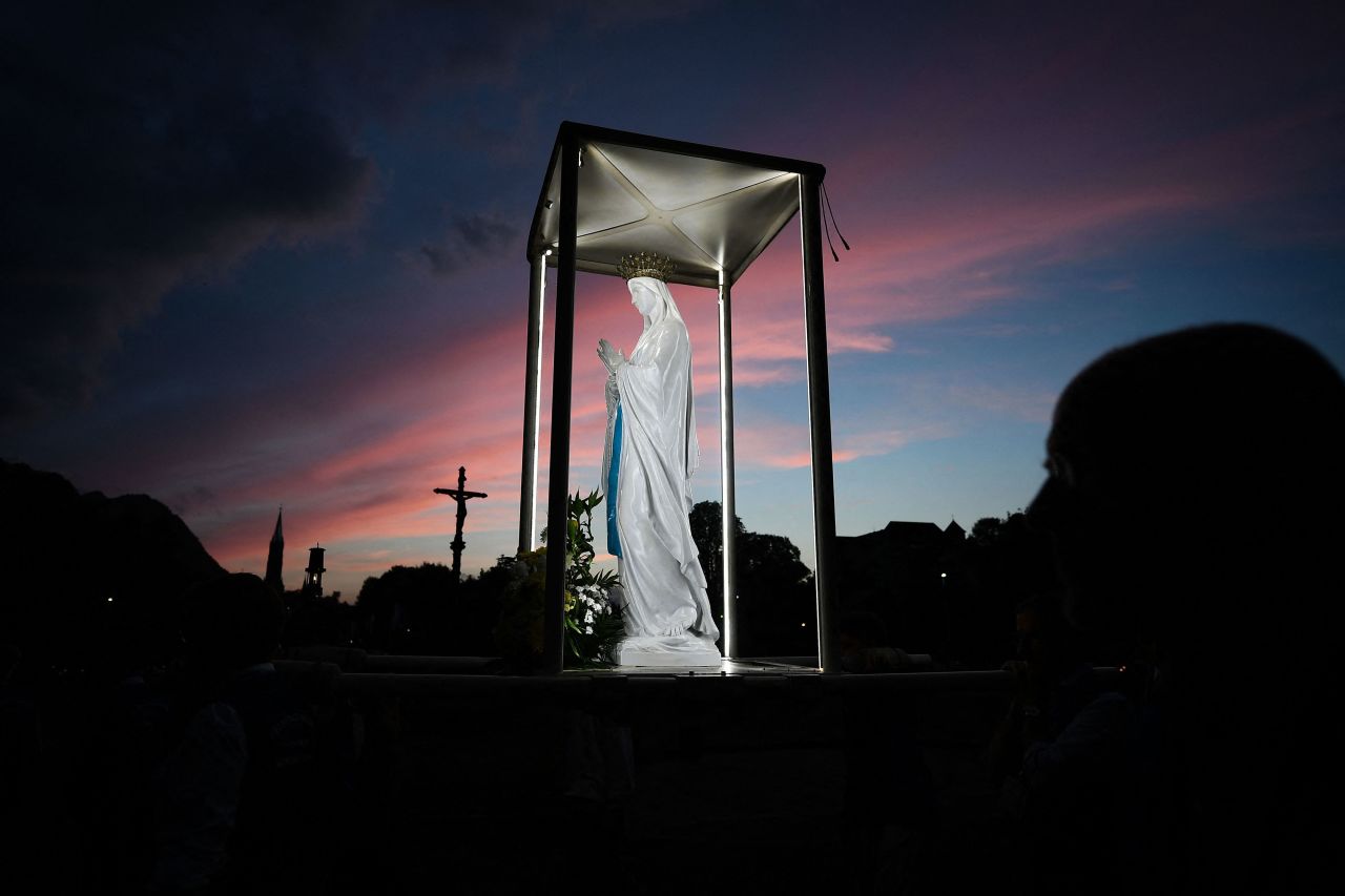 Volunteers carry a replica of the Cabuchet Statue of the Virgin Mary during the Torchlight Marian procession in Lourdes, France, on Sunday, August 14.