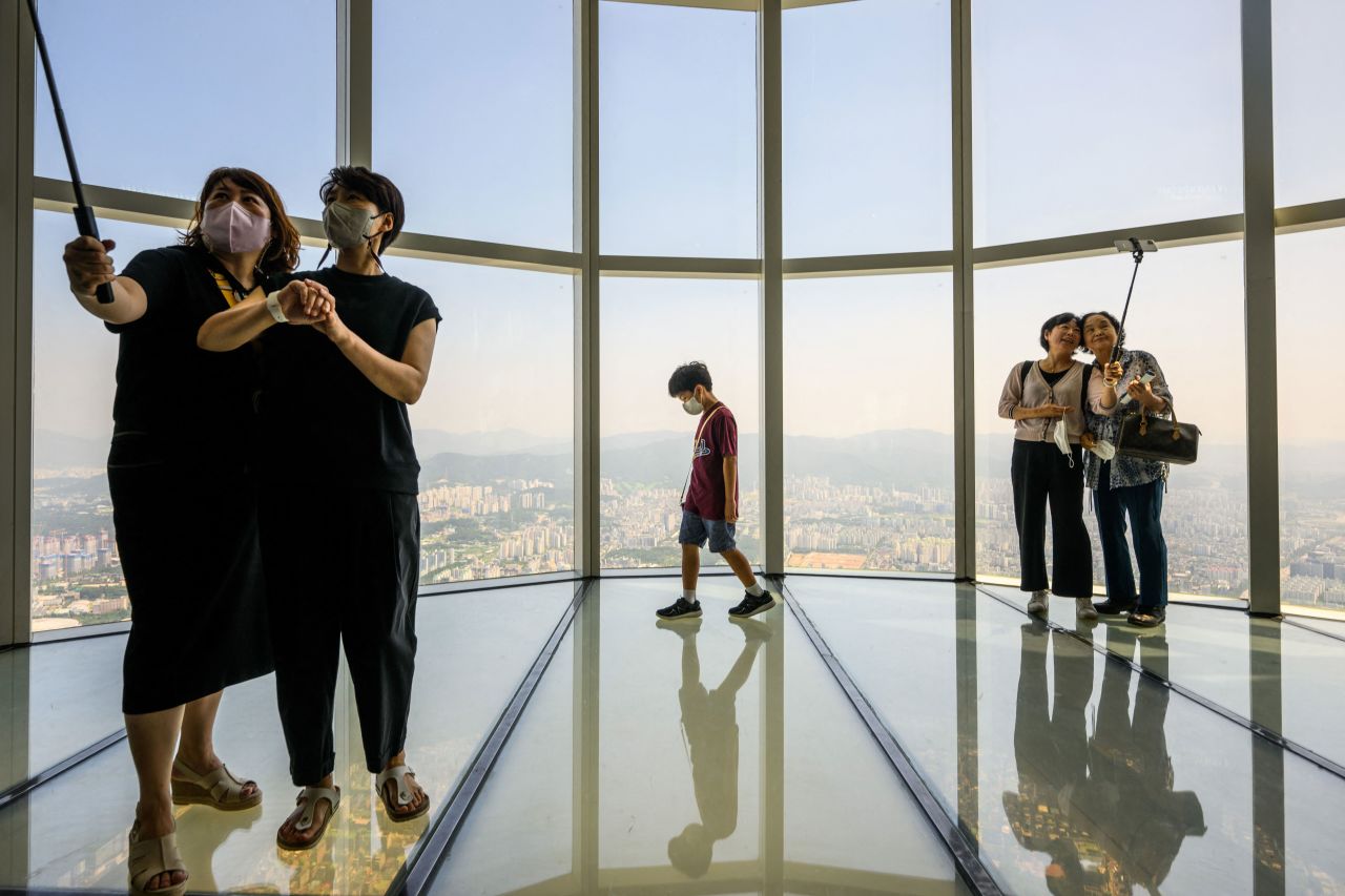 Visitors pose for selfies as a young boy walks on the observation deck of the Seoul Sky Observatory atop the Lotte World Tower in Seoul, South Korea, on Friday, August 12. <a href="https://www.cnn.com/2022/08/11/world/gallery/photos-this-week-august-4-august-11/index.html" target="_blank">See last week in 31 photos.</a>