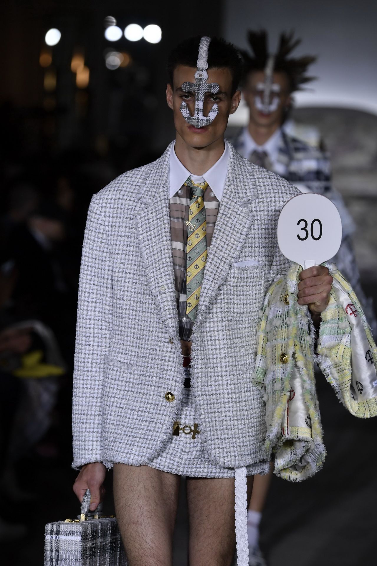 A male model wears a miniskirt on the runway during designer Thom Browne's Ready to Wear Spring-Summer 2023 fashion show.