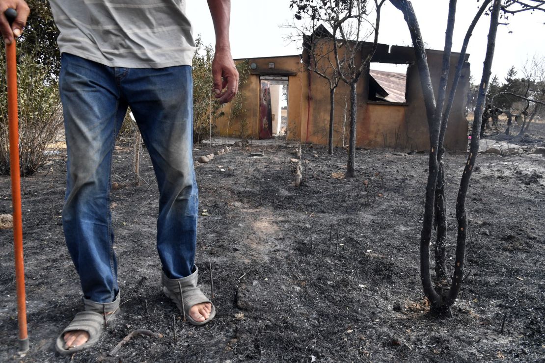 A man walks in front of his home after it was destroyed by a wildfire in the Algerian city of el-Kala, on August 18. Dozens were killed and many more injured on Wednesday in wildfires that ravaged the mountainous areas in Algeria's east. Authorities said that 2,600 hectares were destroyed as a result of the blazes.  