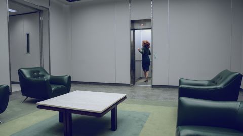 As Helly (Britt Lower) escapes out the window, she passes a sea of Lumon green chairs and carpet. (She's wearing it, too.)