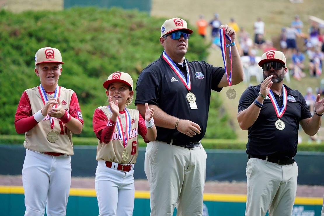 Jace Oliverson, center, father of Little Leaguer Easton Oliverson holds Easton's medal, with another son, Brogan Oliverson (6) at his side before a baseball game against Nolensville, Tennessee, at the Little League World Series on Friday. 