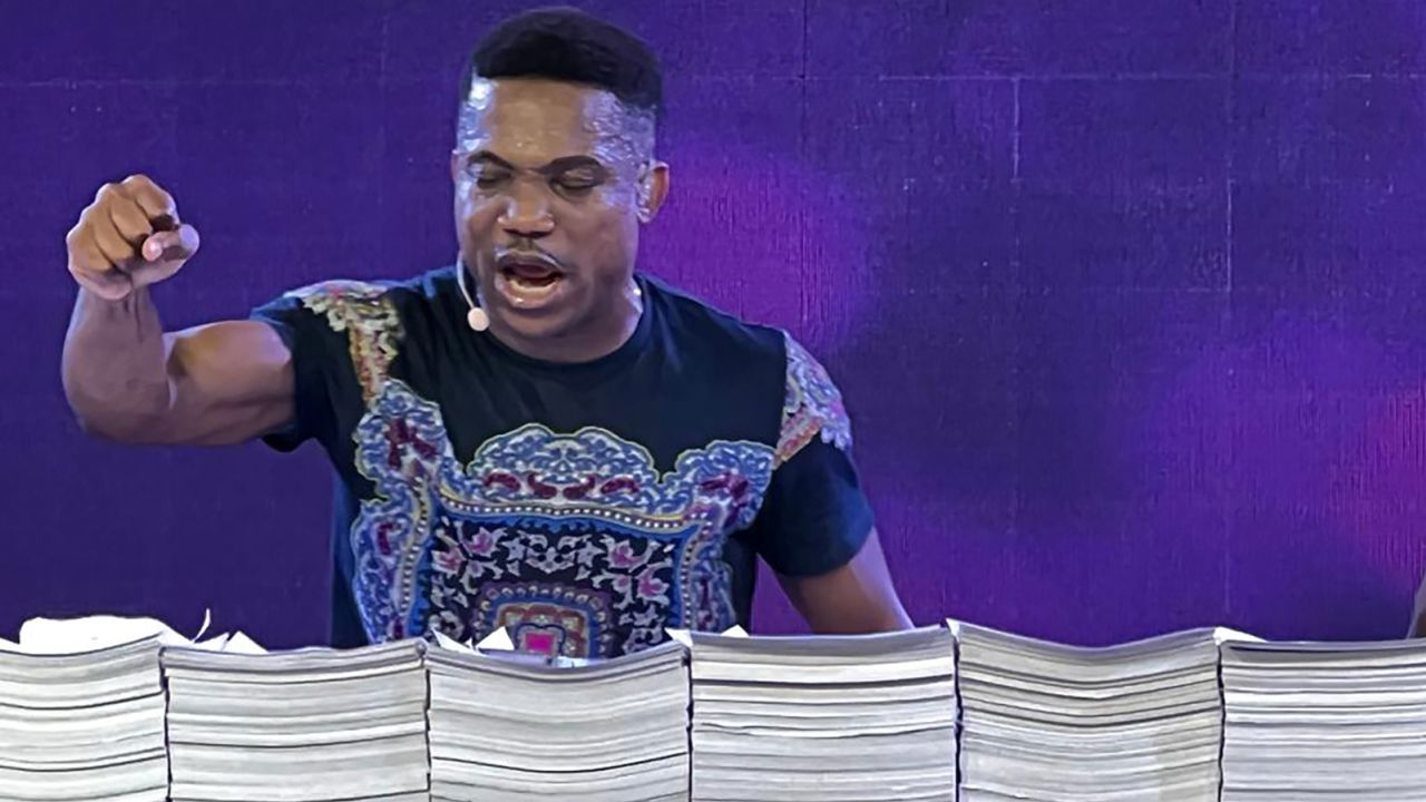 Nigerian preacher Jerry Eze prays over stacks of requests received from his followers