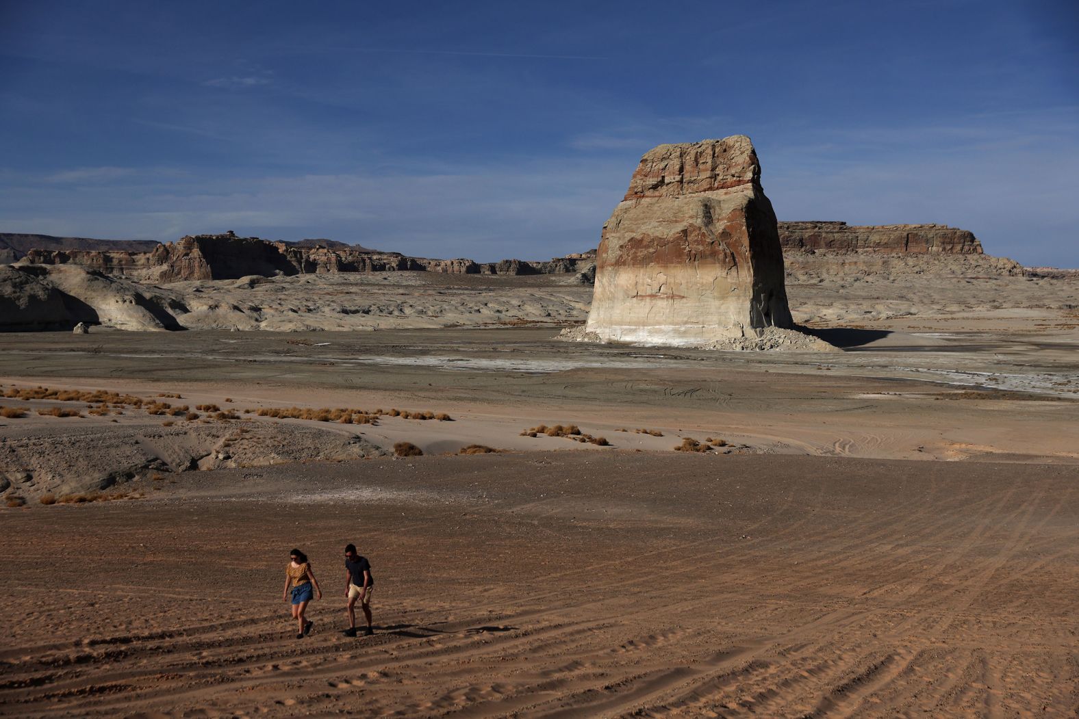 People walk on an area of Lake Powell that used to be underwater at Lone Rock Beach in Big Water, Utah, on March 27.