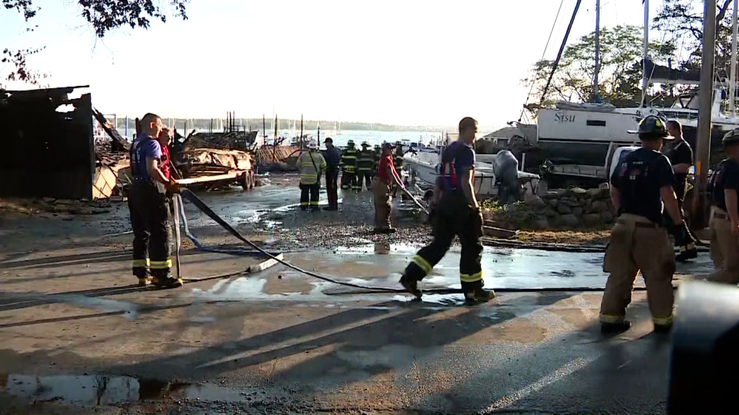 Firefighters work at the scene of a massive boatyard fire in Mattapoisett, Massachusetts on Friday. 