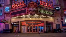 Pedestrians pass in front of a Regal Cinemas movie theater at sunset in New York, U.S., on Tuesday, Oct. 6, 2020. More than 7,000 movie screens will be dark in the U.S. this weekend as the Regal theater chain said it will shut down all 536 locations on Thursday. Photographer: Amir Hamja/Bloomberg via Getty Images