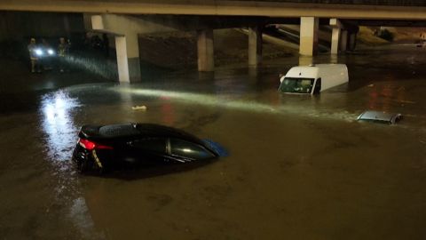 Motorists escape flooded vehicles early Monday in downtown Dallas.