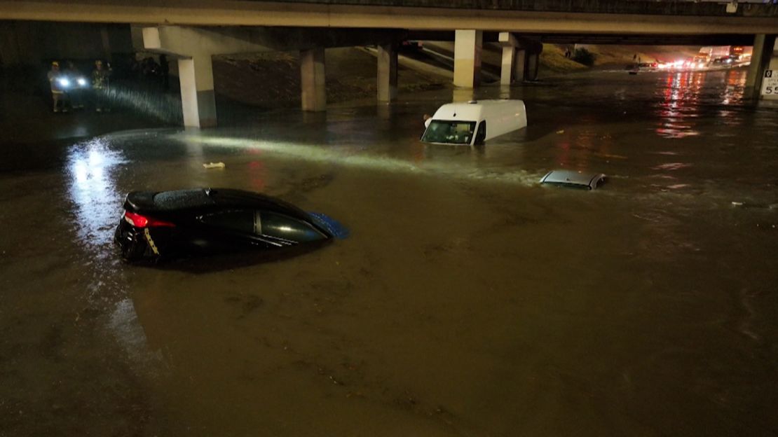 Motorists escape flooded vehicles early Monday in downtown Dallas.