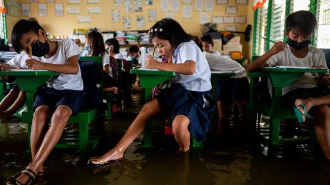 Students attend the first day of in-person classes, at a flooded school due to high tide, in Macabebe, Pampanga province, Philippines, August 22, 2022.