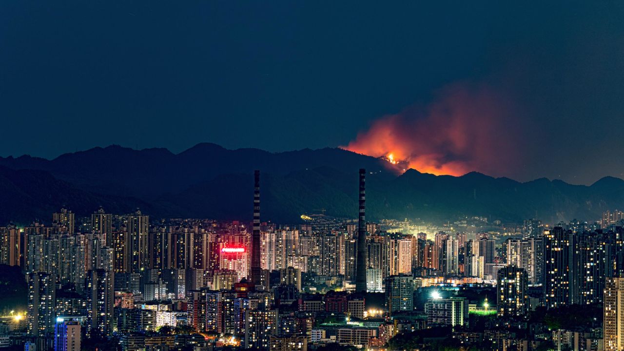 Smoke and flames rise into the sky from a mountain forest fire triggered by persistent drought and heat waves in Chongqing, China on August 21.