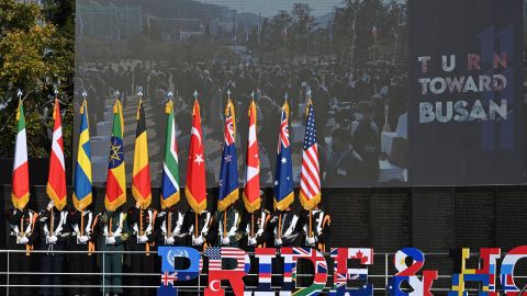 South Korean honor guards carry flags of the UN allied nations during a memorial ceremony for UN veterans of the Korean War, at the UN Memorial Cemetery in Busan on November 11, 2020.